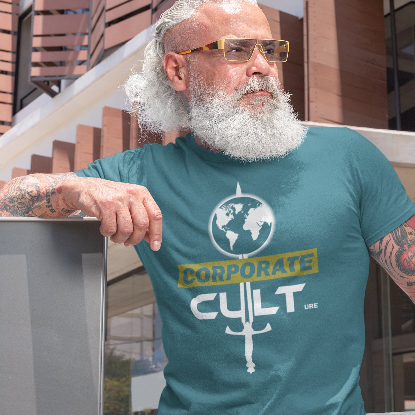 Man wearing a stargazer t-shirt with 'Corporate Cult' graphic design outdoors. This anti corporate t shirt suggests the corporate mind set and dehumanisation of people is like that of a religious cult. Welcome to corporate culture, the enemy of the planet. Made from 100% organic ring-spun cotton, these social issues t shirts are unisex, high-quality and eco-friendly.