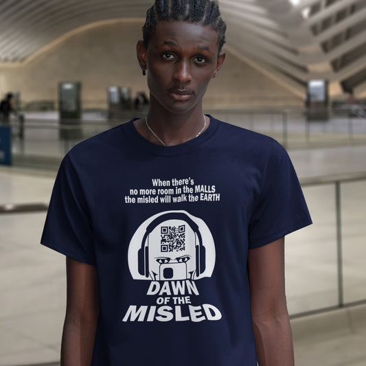 Man in a train station, wearing a French navy blue, short sleeved , crew necked t-shirt with a play on the "DAWN OF THE DEAD" movie cover. The alternative text reading "DAWN OF THE MISLED" with a man on a smartphone design.