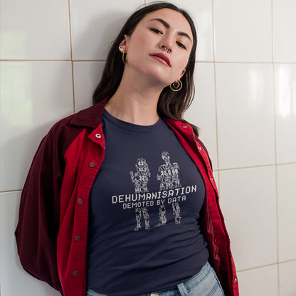 Person wearing a dark blue t-shirt with text and graphics, standing against a tiled wall. This broken society t shirt depicts the dehumanisation of the species by analysis and data collection. The more we view each other as statistics and numbers the further we move away from compassion and empathy. This design highlights the dark side of progression. Made from 100% organic ring-spun cotton, this dystopian t shirt is unisex, high-quality, super comfy, and best of all, eco-friendly.