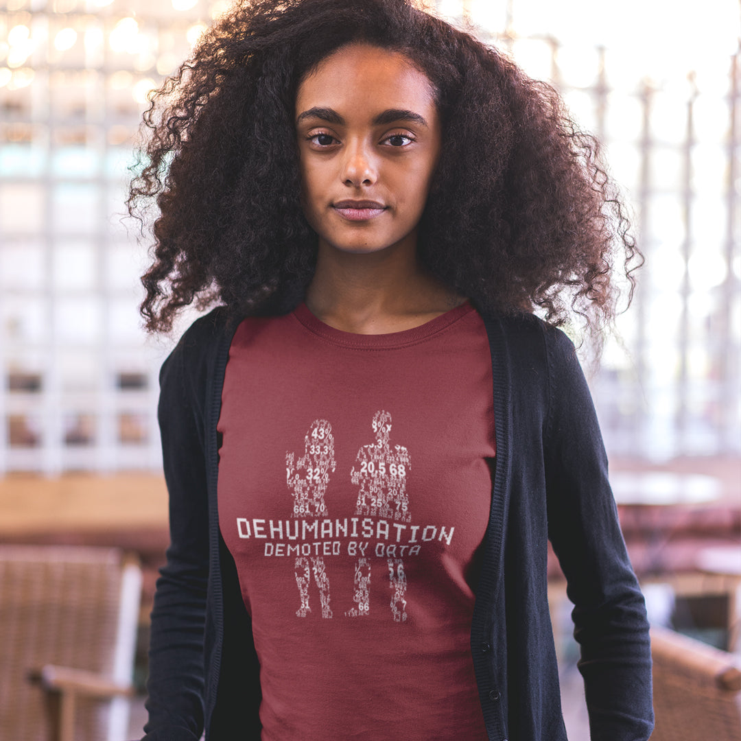 Person wearing a maroon t-shirt with text and graphics, standing indoors. This broken society t shirt depicts the dehumanisation of the species by analysis and data collection. The more we view each other as statistics and numbers the further we move away from compassion and empathy. This design highlights the dark side of progression. Made from 100% organic ring-spun cotton, this dystopian t shirt is unisex, high-quality, super comfy, and best of all, eco-friendly.