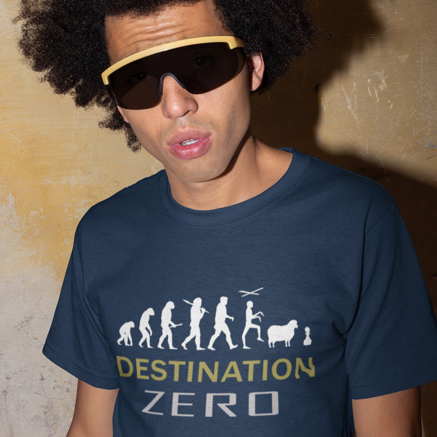 Person wearing a French navy blue t-shirt with 'Destination Zero' graphic design. A sign of the times t shirt design suggesting a de-evolution of humankind. As we rely more and more on technology to do our thinking for us, It's starting to look like we are not destined for great things as a race. Made from 100% organic ring-spun cotton, this social awareness t-shirt is unisex, high-quality, super comfy, and best of all, eco-friendly.