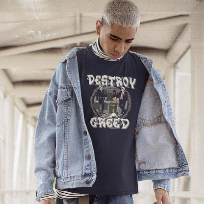 A person wearing a dark French navy graphic t-shirt with 'DESTRUCTION GREED' printed on the front, layered under a light blue denim jacket, set against a blurred concrete corridor background.