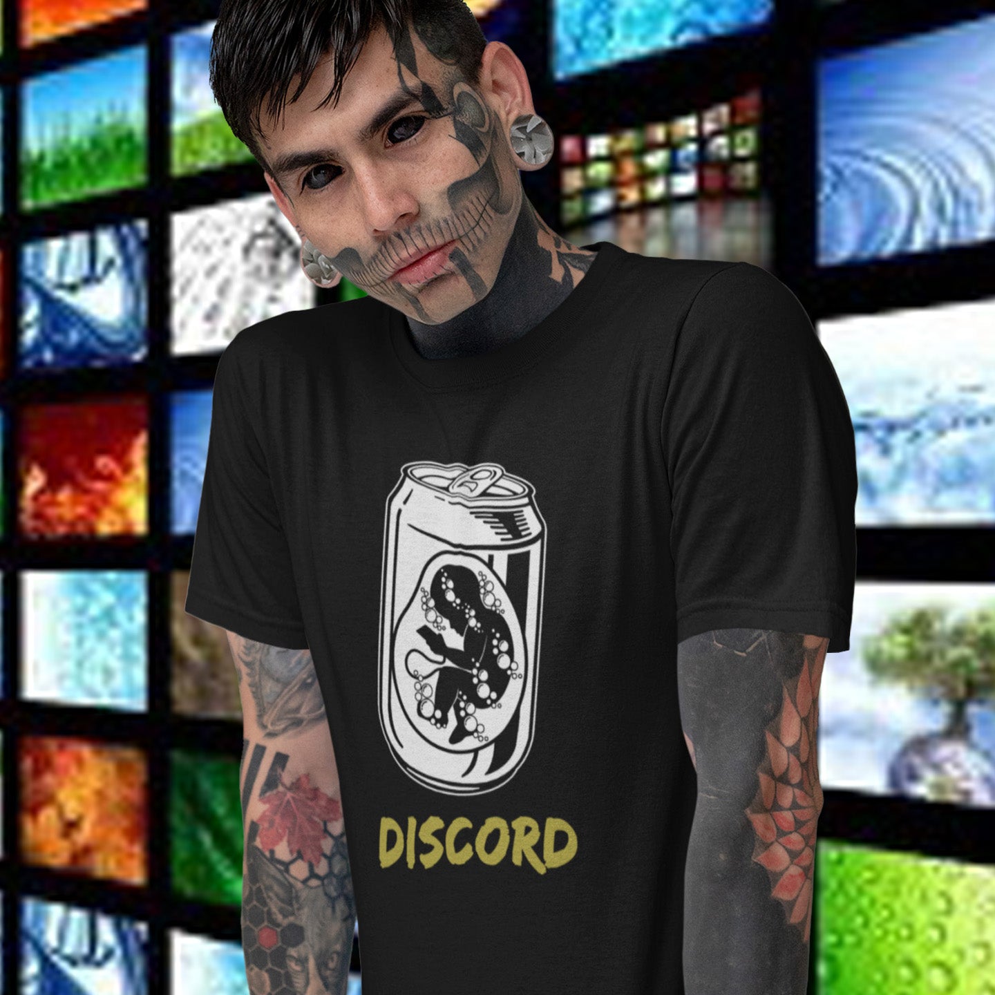 Person wearing a black t-shirt with a Discord logo in front of a colourful screen display. A stencil graffiti t shirt suggesting a discord between modern generations and nature. A street art t shirt testament to the soda pop generation. Brought up on energy drinks and born with a Wi-Fi connection. Made from 100% organic ring-spun cotton, this urban art t shirt is unisex, high-quality, super comfy, and best of all, eco-friendly.
