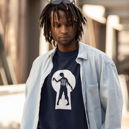 A man with dreadlock hair and sunglasses, standing outside, wearing a French navy blue t-shirt with a zombie through a key hole design with "DON'T BE BLINDED BY THE HIVE MINDED" text.