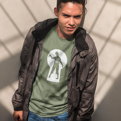 A man wearing a dark brown jacket over an khaki green  t-shirt with a zombie through a key hole design with "DON'T BE BLINDED BY THE HIVE MINDED" text.