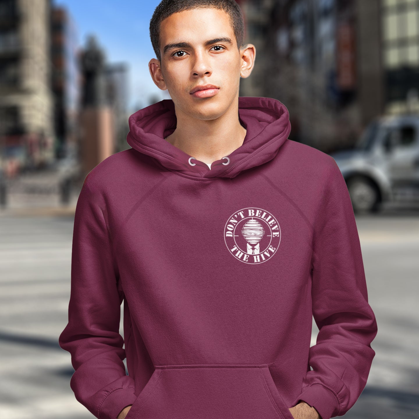 Person wearing a burgundy hoodie with a logo on a city street. A anti establishment hoodie. In an ever increasing world of media influence and misinformation, can 'The Majority' be trusted any more ? Don't get blinded by the hive minded. Support independent thought with this unique hoodie. Comfortable and practical. It's extra soft and has a convenient front pouch pocket. Made from organic cotton and recycled polyester, this social awareness hoodie is a great eco-friendly choice.