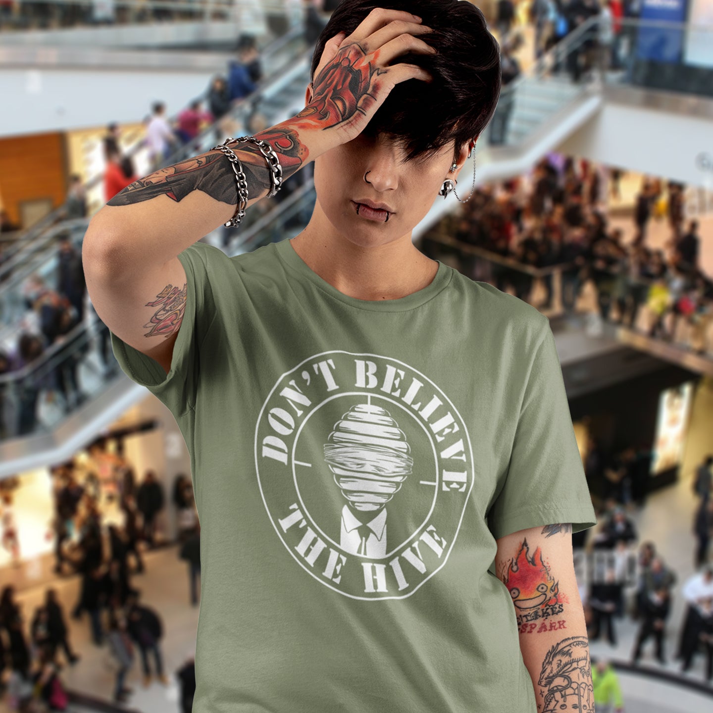 Person wearing a khaki t-shirt with a graphic design in a mall setting. A street art t shirt design for an ever increasing world of media influence and misinformation. Can 'The Majority' be trusted any more ? Don't get blinded by the hive minded. Support independent thought with this unique urban art t shirt. Made from 100% organic ring-spun cotton, this social awareness t shirt is unisex, high-quality, super comfy, and best of all, eco-friendly.
