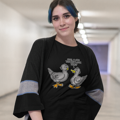 Person wearing a black t-shirt with graphic design and text in an indoor setting, A social issues t shirt design mocking the idea of lip fillers. In a alternative reality are ducks having surgery to make their lips look like humans ? Counterculture cartoon. Made from 100% organic ring-spun cotton, this social awareness t shirt is unisex, high-quality, super comfy, and best of all, eco-friendly.