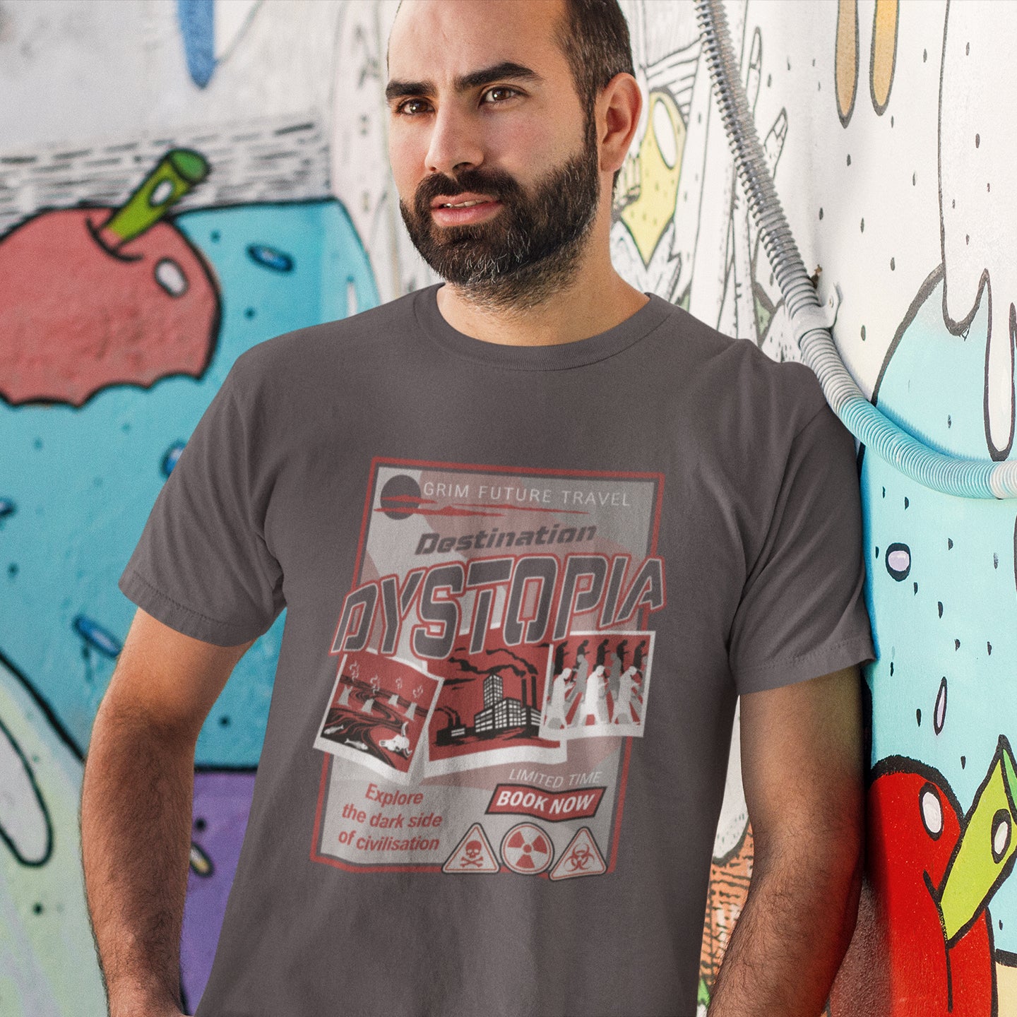 Man wearing a t-shirt with 'Destination Dystopia' design in front of a colourful mural. This funny dystopian t-shirt design is a clever play on a tourism poster promoting dystopia as a satirical holiday destination. If you feel that our system of inequality will render any holiday to the western world a holiday in Dystopia, this design will truly represent your feelings. Made from 100% organic ring-spun cotton, this broken society t shirt is unisex, high-quality, super comfy, and best of all, eco-friendly.