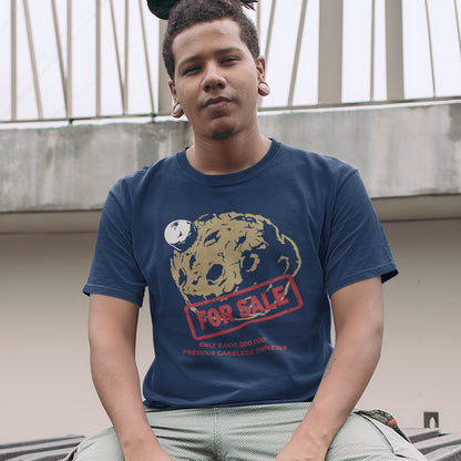 Person wearing a French navy blue t-shirt with a graphic design sitting outdoors. A save the world t-shirt design playing on the car sales slogan 'One careful previous owner' You know we'll try to sell the planet when we're finished with it. Environmental awareness sooner than later. Made from 100% organic ring-spun cotton, this save the earth t shirt is unisex, high-quality, super comfy, and best of all, eco-friendly.