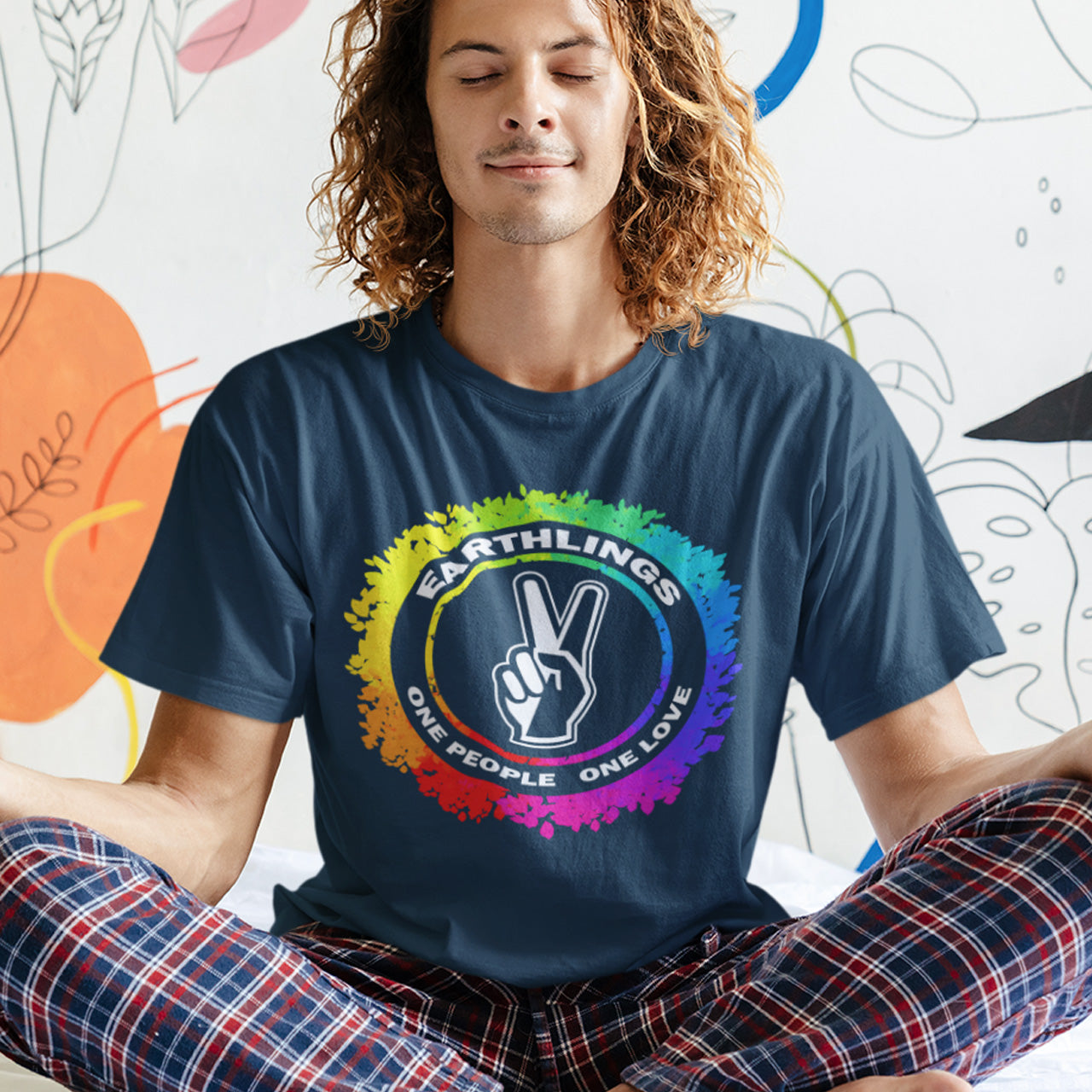 Person wearing a French navy blue t-shirt with an Earthling logo and text, sitting against a colourful abstract background. This ant-prejudice t-shirt is LGTBQ+ friendly and anti-racism. We are all Earthlings and can live in peace and harmony if we put aside our prejudice and fear. This original design promotes social awareness and unity. Made from 100% organic ring-spun cotton, this anti prejudice t-shirt is unisex, high-quality, super comfy, and best of all, eco-friendly.