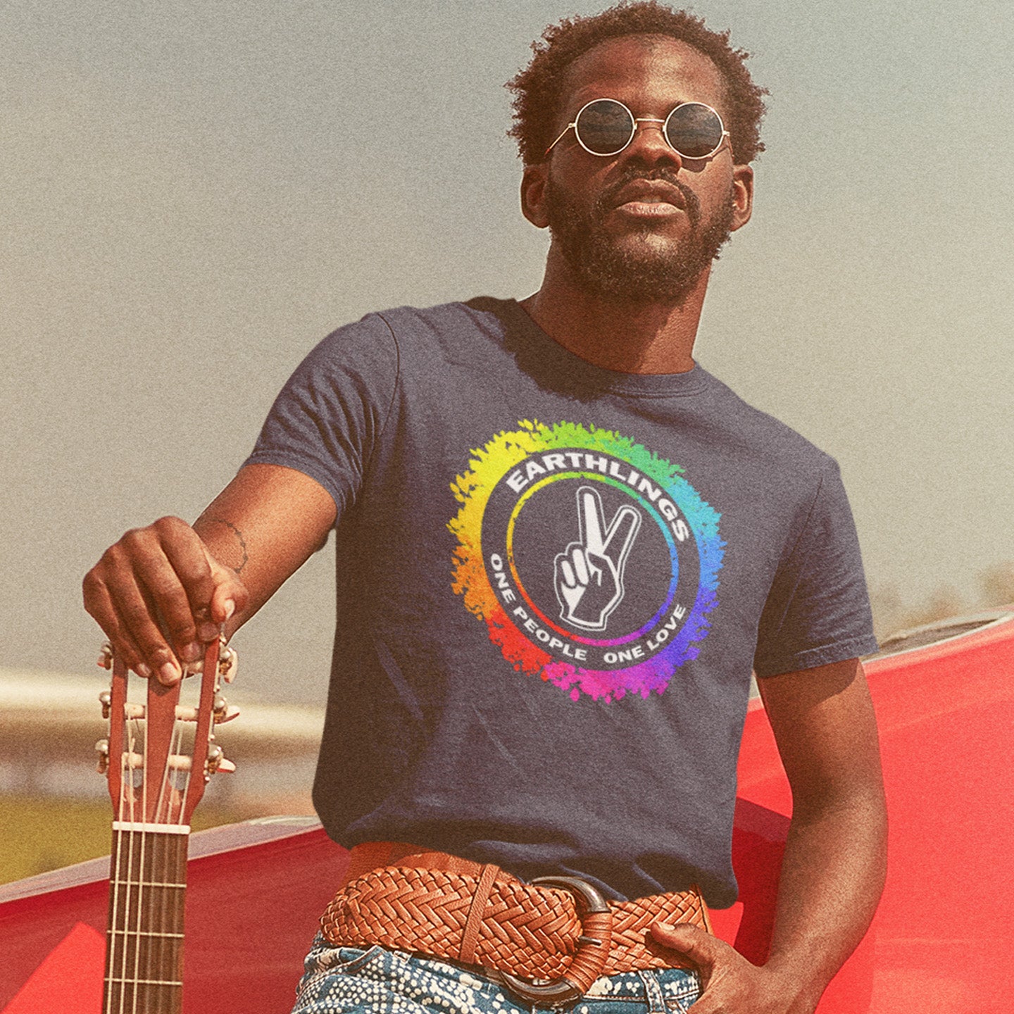 Man wearing a t-shirt with a rainbow peace symbol design, holding a guitar. This ant-prejudice t-shirt is LGTBQ+ friendly and anti-racism. We are all Earthlings and can live in peace and harmony if we put aside our prejudice and fear. This original design promotes social awareness and unity. Made from 100% organic ring-spun cotton, this anti prejudice t-shirt is unisex, high-quality, super comfy, and best of all, eco-friendly.