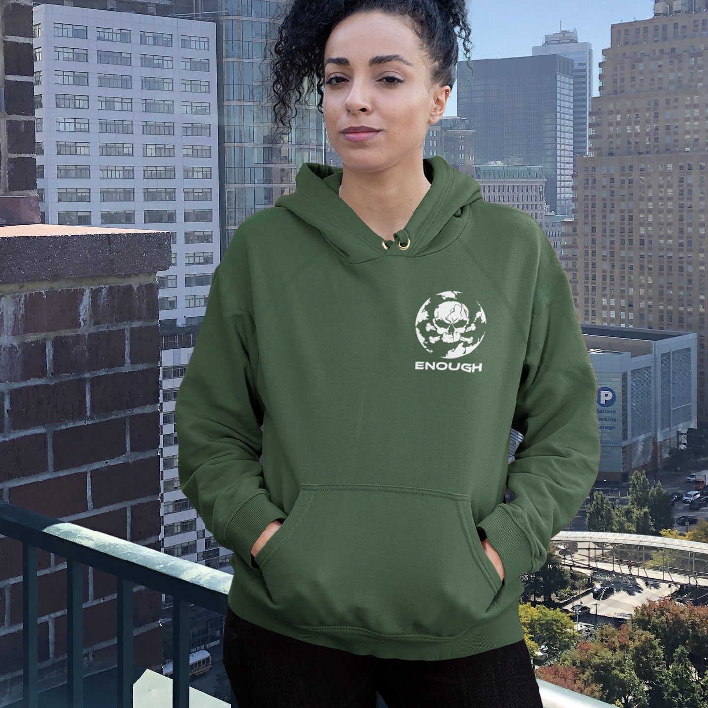Woman wearing bottle green hoodie on a building roof. An environmental hoodie highlighting an overcrowding concern. This original design is for all nature lovers who think that enough is enough and don't want to live in a concrete jungle. Comfortable and practical. It's extra soft and has a convenient front pouch pocket. Made from organic cotton and recycled polyester, this social awareness hoodie is a great eco-friendly choice.