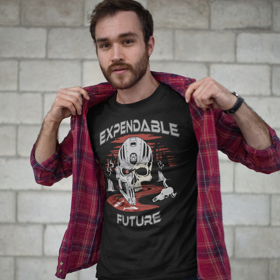 Man wearing a black t-shirt with 'Expendable Future' graphic design, standing against a light brick wall. A dystopian t shirt suggesting that our impact on the planet is not been taken seriously enough, is it time to worry about our role as working humans? Counterculture and alternative view of technology and modern society. Made from 100% organic ring-spun cotton, this social awareness t shirt is unisex, high-quality, super comfy, and best of all, eco-friendly.