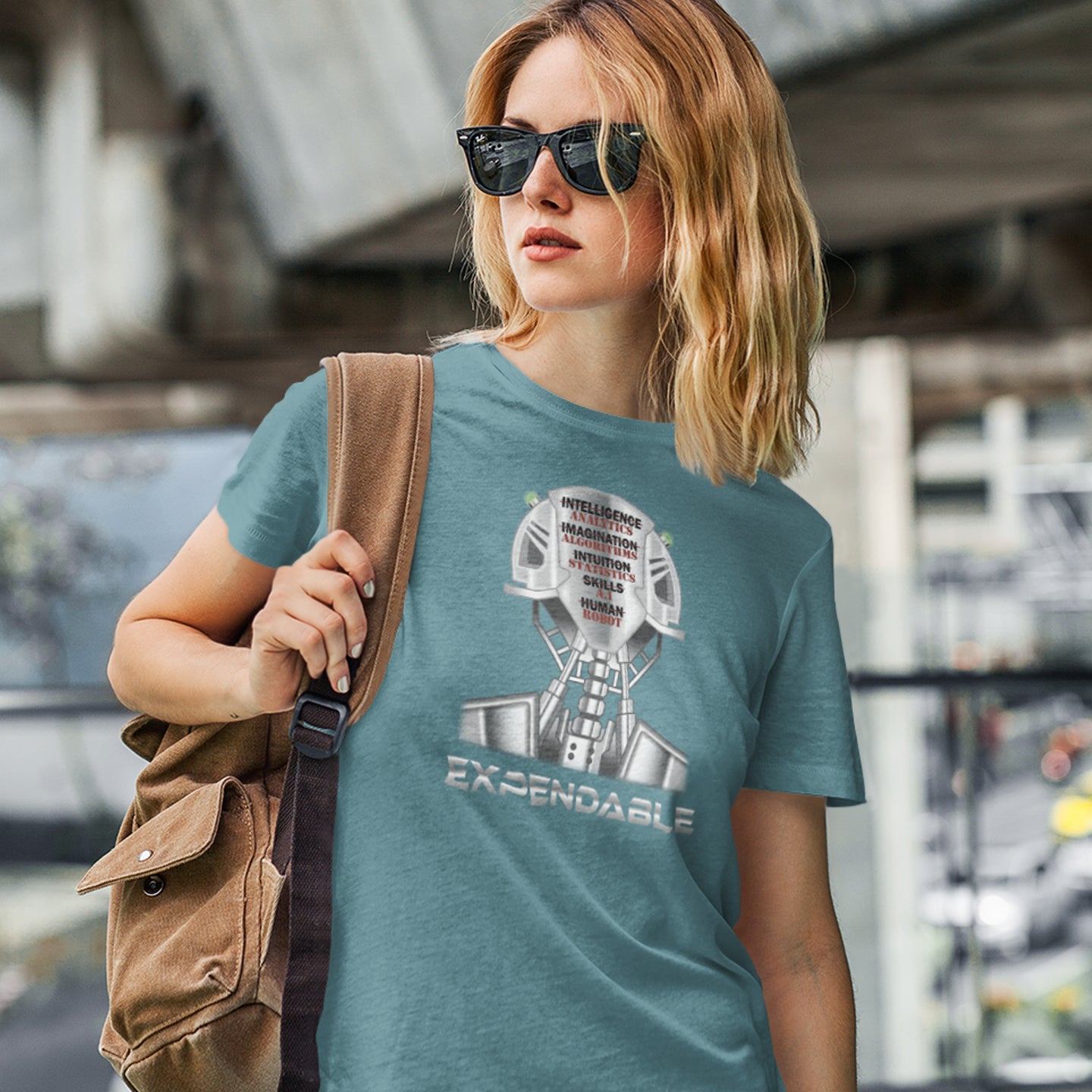 Woman wearing a blue t-shirt with a graphic design and sunglasses, standing in an urban setting. An anti-technology t-shirt suggesting that too many attributes of human development are being replaced by a computer program, is it time to worry about our role as humans ? Counterculture and alternative view of technology. Made from 100% organic ring-spun cotton, this social awareness, anti technology t-shirt is unisex, high-quality, super comfy, and best of all, eco-friendly.