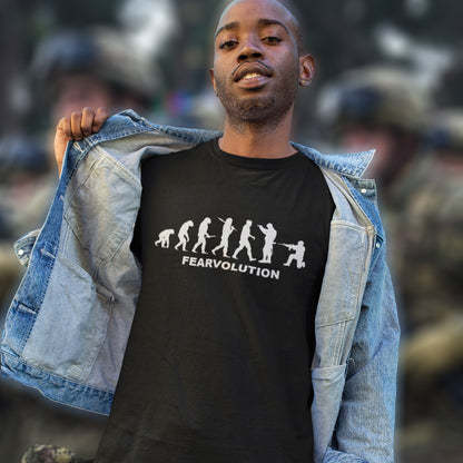 Man wearing a black t-shirt with 'FEARVOLUTION' design and denim jacket against a blurred background. This satirical 'theory of evolution' t-shirt displays an alternative view of how we may evolve from here on. Fear is holding us back, fear of change. Made from 100% organic ring-spun cotton, this philosophy t-shirt is unisex, high-quality, super comfy, and best of all, eco-friendly.