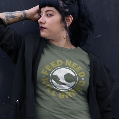 Person wearing a green t-shirt with 'Feed Need Kill Greed' text and graphic design. An anti government t shirt. At the root of most political corruption is the concentration of greed over need. Made from 100% organic ring-spun cotton, this dystopian t shirt design is unisex, high-quality, super comfy, and best of all, eco-friendly.
