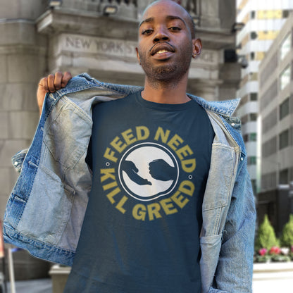 Man wearing a t-shirt with a graphic and text in an urban setting. An anti-greed protest t-shirt. At the root of most political corruption is the concentration of greed over need. Made from 100% organic ring-spun cotton, this political t-shirt is unisex, high-quality, super comfy, and best of all, eco-friendly.