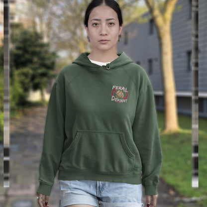 Person wearing a green hoodie with a logo outdoors. A non conformist hoodie for people who think boundaries stifle creativity, and rules are only guidelines. This alternative, anti establishment hoodie is perfect for any demonstration or protest march of your choice. Comfortable and practical. It's extra soft and has a convenient front pouch pocket. Made from organic cotton and recycled polyester, this street art inspired hoodie is a great eco-friendly choice.