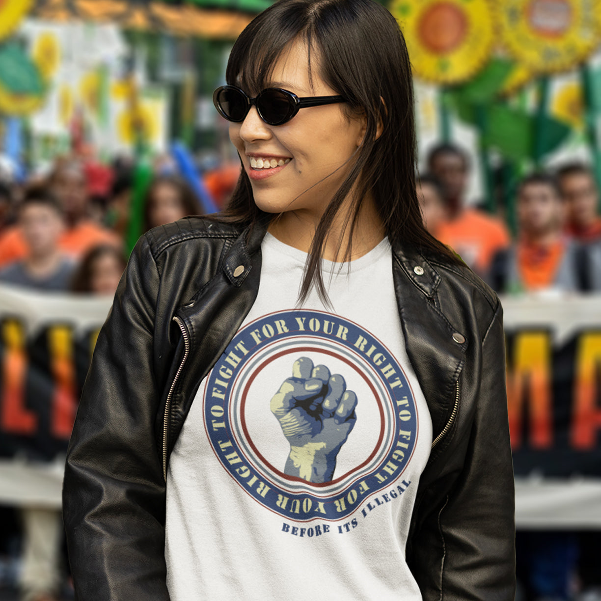 Woman wearing a white t-shirt with a graphic design and black leather jacket in front of a blurred crowd. A civil rights t-shirt reminding us not to take our freedom for granted. Fight for your right to demonstrate before it's made illegal. Made from 100% organic ring-spun cotton, this anti-establishment t-shirt is unisex, high-quality, super comfy, and best of all, eco-friendly.
