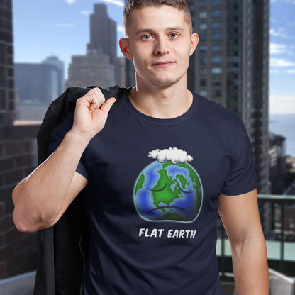 Person wearing a French navy blue t-shirt with a 'Flat Earth' graphic and text, standing in an urban setting. This funny conspiracy theorist t shirt plays on the idea of the earth being flat. Could it just be a little bored or depressed. Made from 100% organic ring-spun cotton, this funny flat earth conspiracy theory t shirt is unisex, high-quality, super comfy, and best of all, eco-friendly.