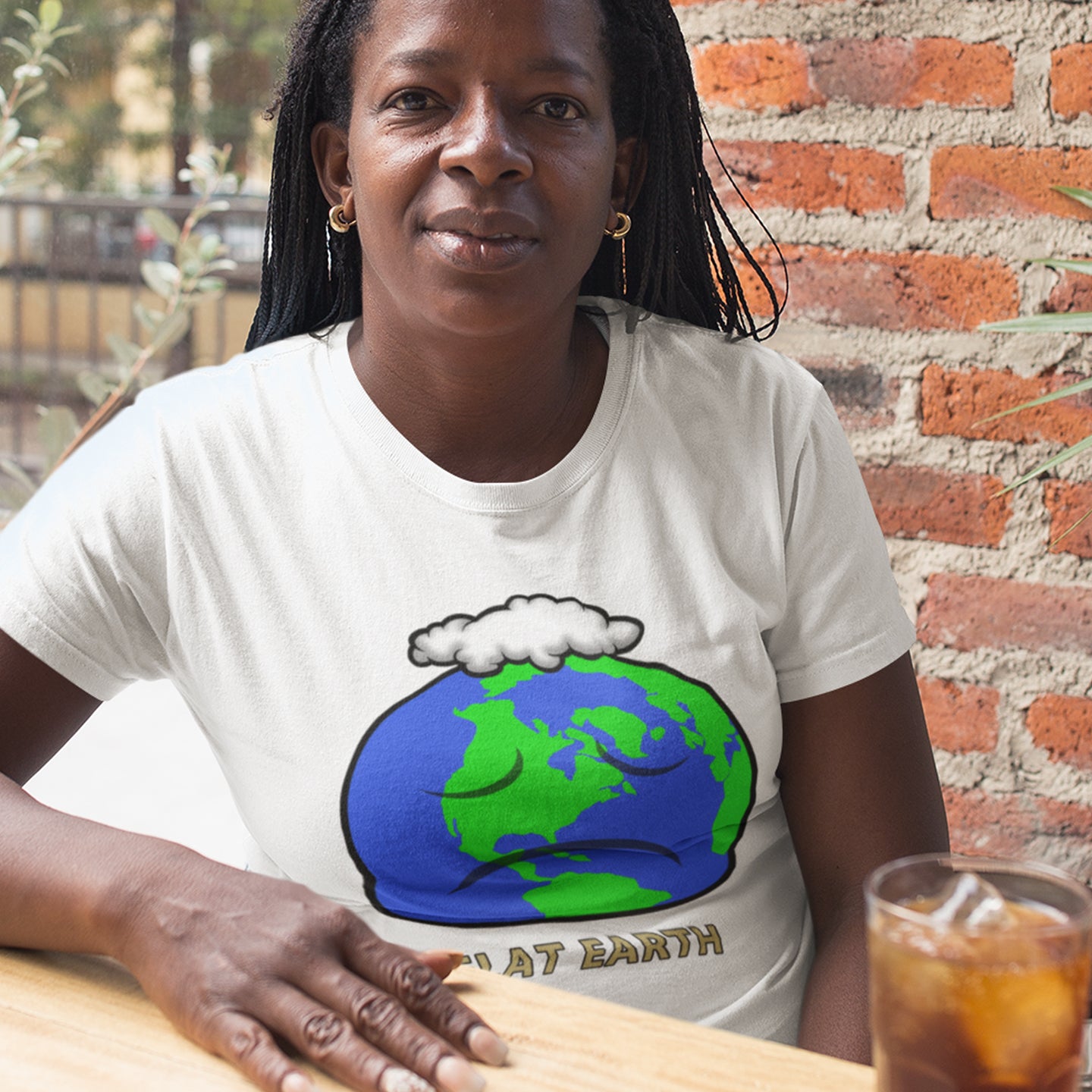 Woman wearing a t-shirt with a graphic of the Earth sitting at a table with a drink. This funny conspiracy theory t-shirt plays on the idea of the earth being flat. Could it just be a little bored or depressed. Made from 100% organic ring-spun cotton, this funny flat earth theory t-shirt is unisex, high-quality, super comfy, and best of all, eco-friendly.