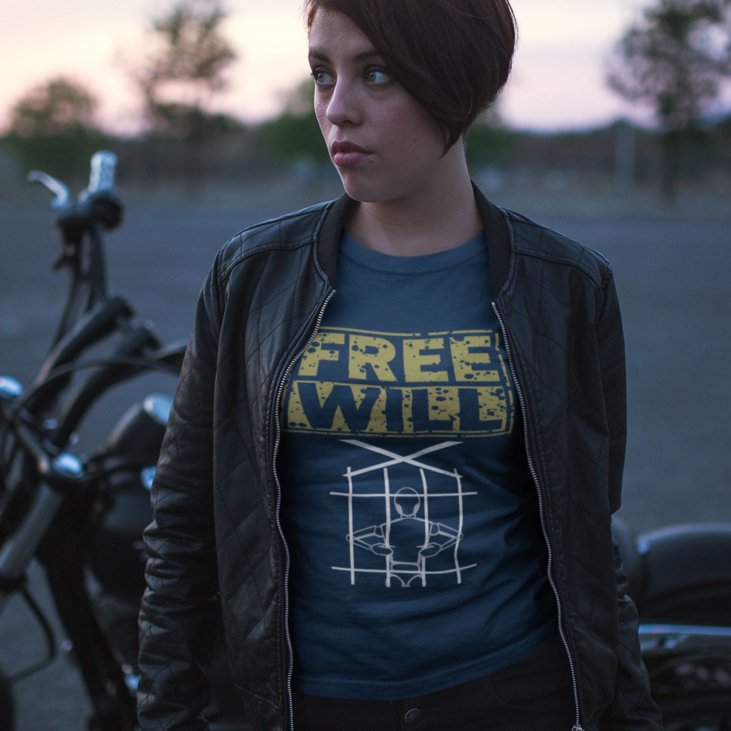 Person wearing a 'Free Will' t-shirt with a motorcycle in the background. A civil liberties t shirt design to promote independent thought and self awareness. If you are feeling overwhelmed by influence, join the 'free will' movement. Made from 100% organic ring-spun cotton, this social awareness t-shirt is unisex, high-quality, super comfy, and best of all, eco-friendly.