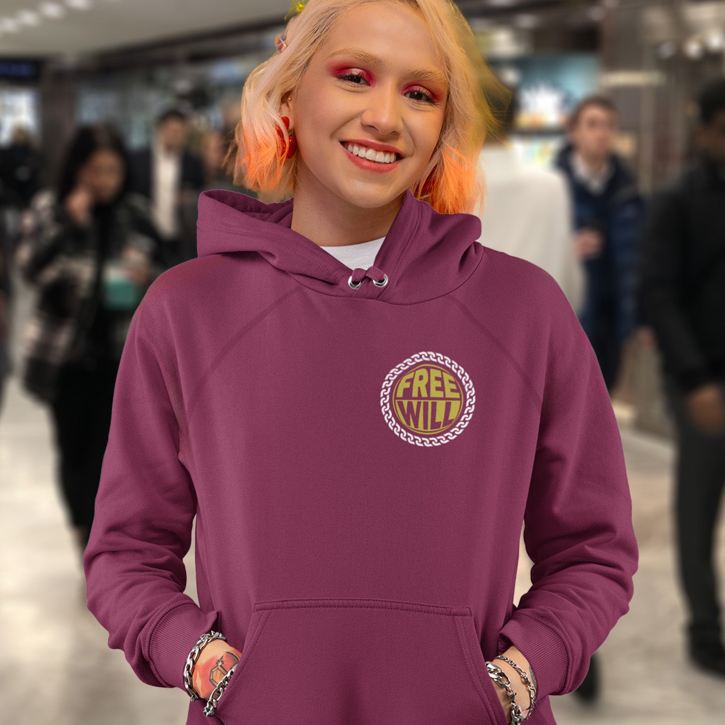 Person wearing a burgundy hoodie with 'Free Will' logo in a blurred indoor setting. A civil rights hoodie design to promote independent thought and self awareness. If you are feeling overwhelmed by influence, join the 'free will' movement. Comfortable and practical. It's extra soft and has a convenient front pouch pocket. Made from organic cotton and recycled polyester, this social awareness hoodie is a great eco-friendly choice.