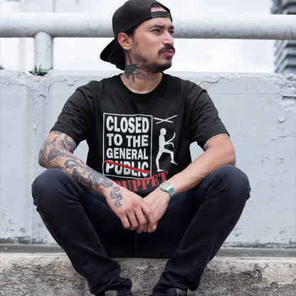 Man wearing a black t-shirt with text and graphics, sitting on a concrete ledge. this non conformist t shirt is for the anti-social alternative thinker who finds the general public a bit predictable and indoctrinated. Made from 100% organic ring-spun cotton, this social awareness t shirt is unisex, high-quality, super comfy, and best of all, eco-friendly.