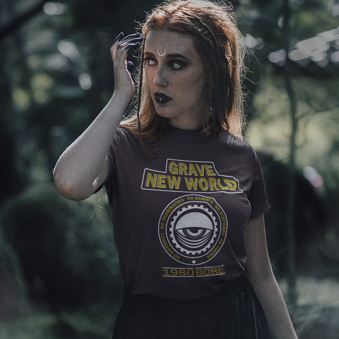 Person wearing a 'Grave New Worlds' t-shirt in a forest setting. A unique non conformist t shirt with a twist of satire. Neither George Orwell or Aldous Huxley mentioned how boring the new world would be under analytics and algorithms. A satirical dystopian t shirt design depicting a counter culture view. Made from 100% organic ring-spun cotton, this non conformist t shirt is unisex, high-quality, super comfy, and best of all, eco-friendly.