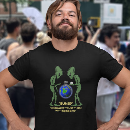 Man wearing a black t-shirt with alien design and text in a crowd. This funny alien t shirt highlights our over use of weaponry. With our lust for guns we must look out of control from an alien view point. No wonder they don't openly reveal themselves to us. Made from 100% organic ring-spun cotton, this counter culture t shirt is unisex, high-quality, super comfy, and best of all, eco-friendly.