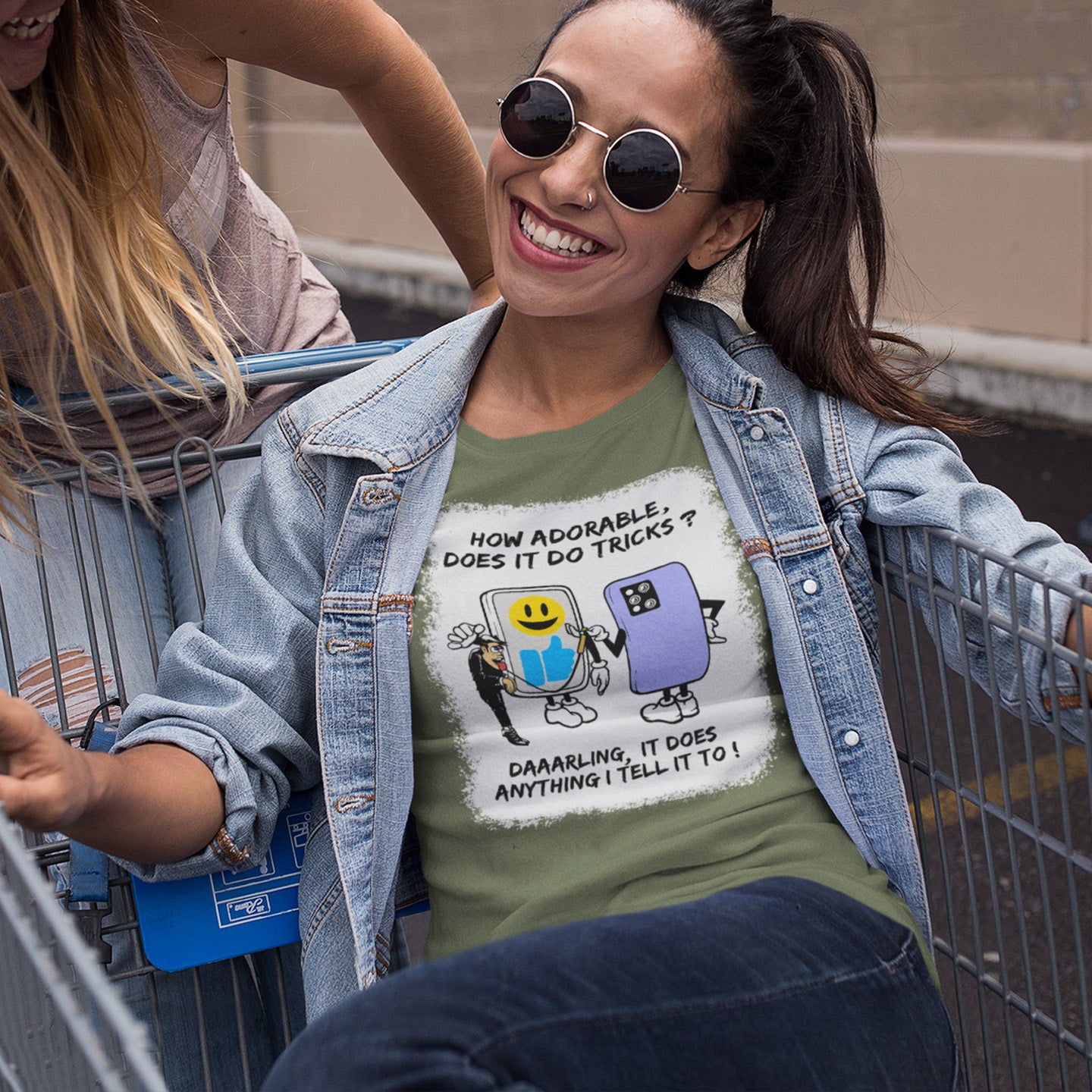 Woman wearing a khaki t-shirt with a graphic design and text, sitting in a shopping cart. An anti mobile phone abuse t-shirt depicting a twisted view of what's really going on in some peoples relationship with their mobile phone. Sometimes you have to wonder who owns who. An original design to promote social awareness. Made from 100% organic ring-spun cotton, this anti smart phone abuse t-shirt is unisex, high-quality, super comfy, and best of all, eco-friendly.