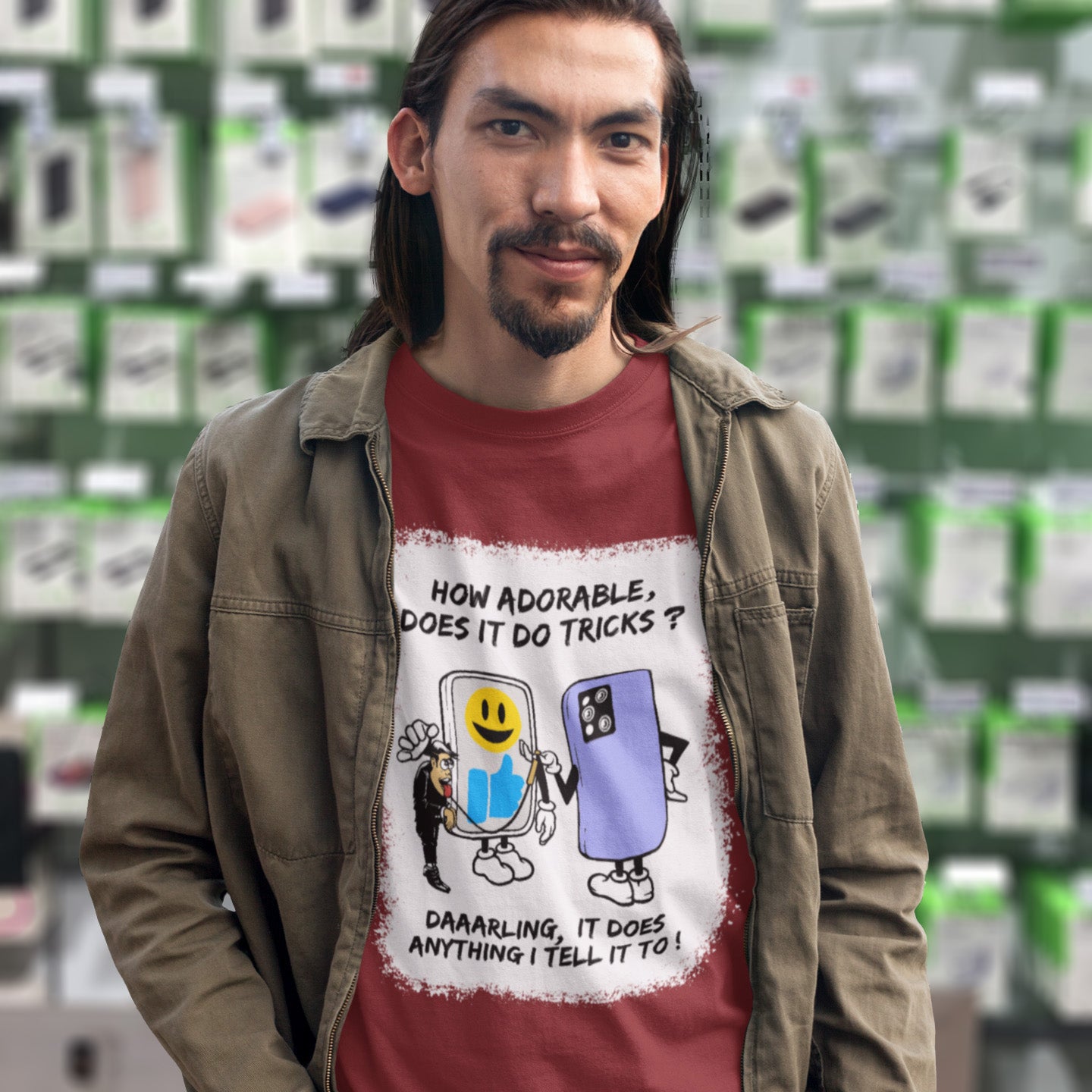 Man wearing a t-shirt with a graphic design and text, standing in front of shelves. An satirical cartoon t-shirt depicting a twisted view of what's really going on in some peoples relationship with their mobile phone. Sometimes you have to wonder who owns who. An original design to promote social awareness. Made from 100% organic ring-spun cotton, this satirical cartoon t-shirt is unisex, high-quality, super comfy, and best of all, eco-friendly.