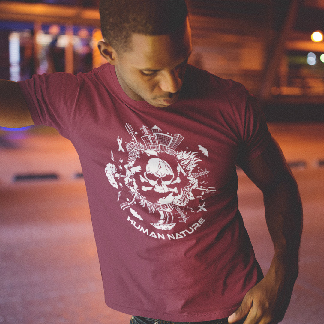 Man wearing a maroon t-shirt with a white graphic design and text, standing in an urban setting at night. This save the world t shirt claims human nature is nowhere near as good as mother nature. It's not only about environmental issues. How do we save the planet from human nature. Made from 100% organic ring-spun cotton, this save the earth t shirt is unisex, high-quality, super comfy, and best of all, eco-friendly.