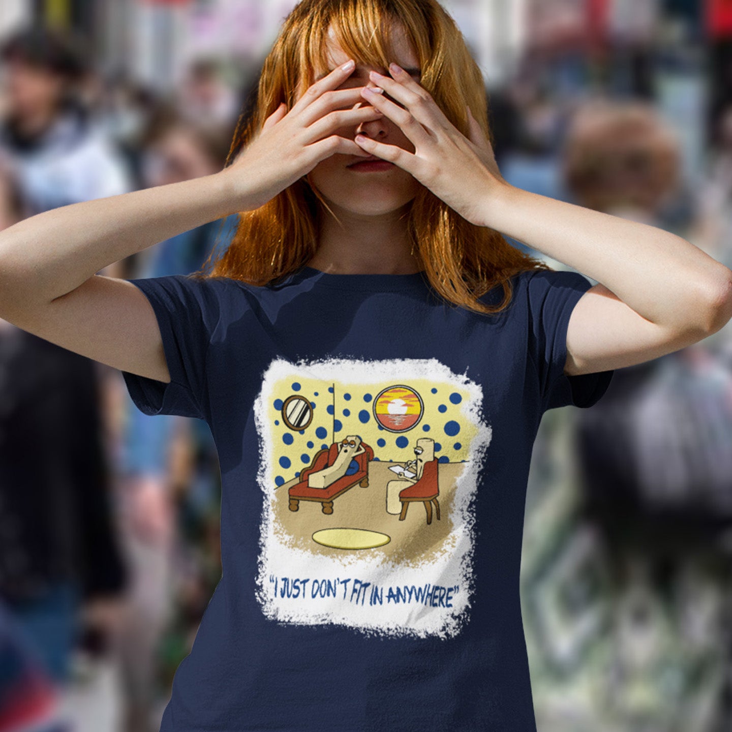 Person wearing a French navy blue t-shirt with a graphic design and text, standing in a blurred crowd. A funny cartoon t-shirt for all you 'square pegs in round holes' out there. You are not alone. This unique design is ideal for anyone who thinks outside the box. Made from 100% organic ring-spun cotton, this witty cartoon t-shirt is unisex, high-quality, super comfy, and best of all, eco-friendly.
