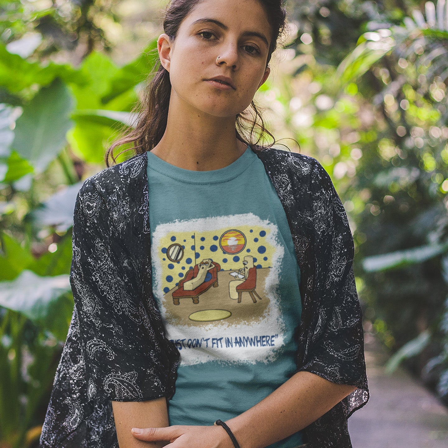 Woman wearing a t-shirt with a graphic design outdoors. A funny cartoon t-shirt for all you 'square pegs in round holes' out there. You are not alone. This unique design is ideal for anyone who thinks outside the box. Made from 100% organic ring-spun cotton, this witty cartoon t-shirt is unisex, high-quality, super comfy, and best of all, eco-friendly.