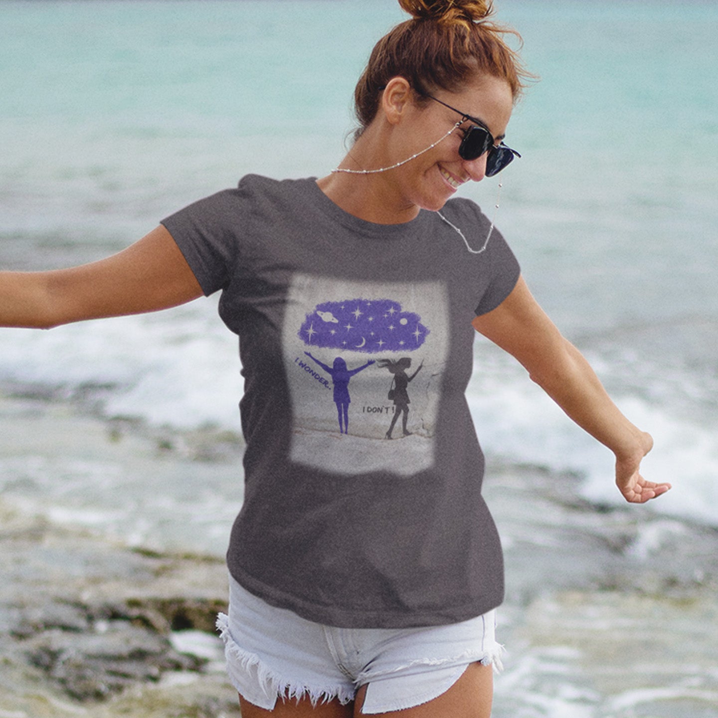 Woman wearing a anthracite t-shirt with a graphic design by the water. This anti mobile phone abuse t shirt light heartedly pokes fun at people who never look up from their phone. If you believe letting a machine do most of your thinking for you will dull your imagination, this satirical design is for you. Made from 100% organic ring-spun cotton, these anti mobile phone abuse t shirts are unisex, high quality, super comfy, and best of all, eco-friendly.