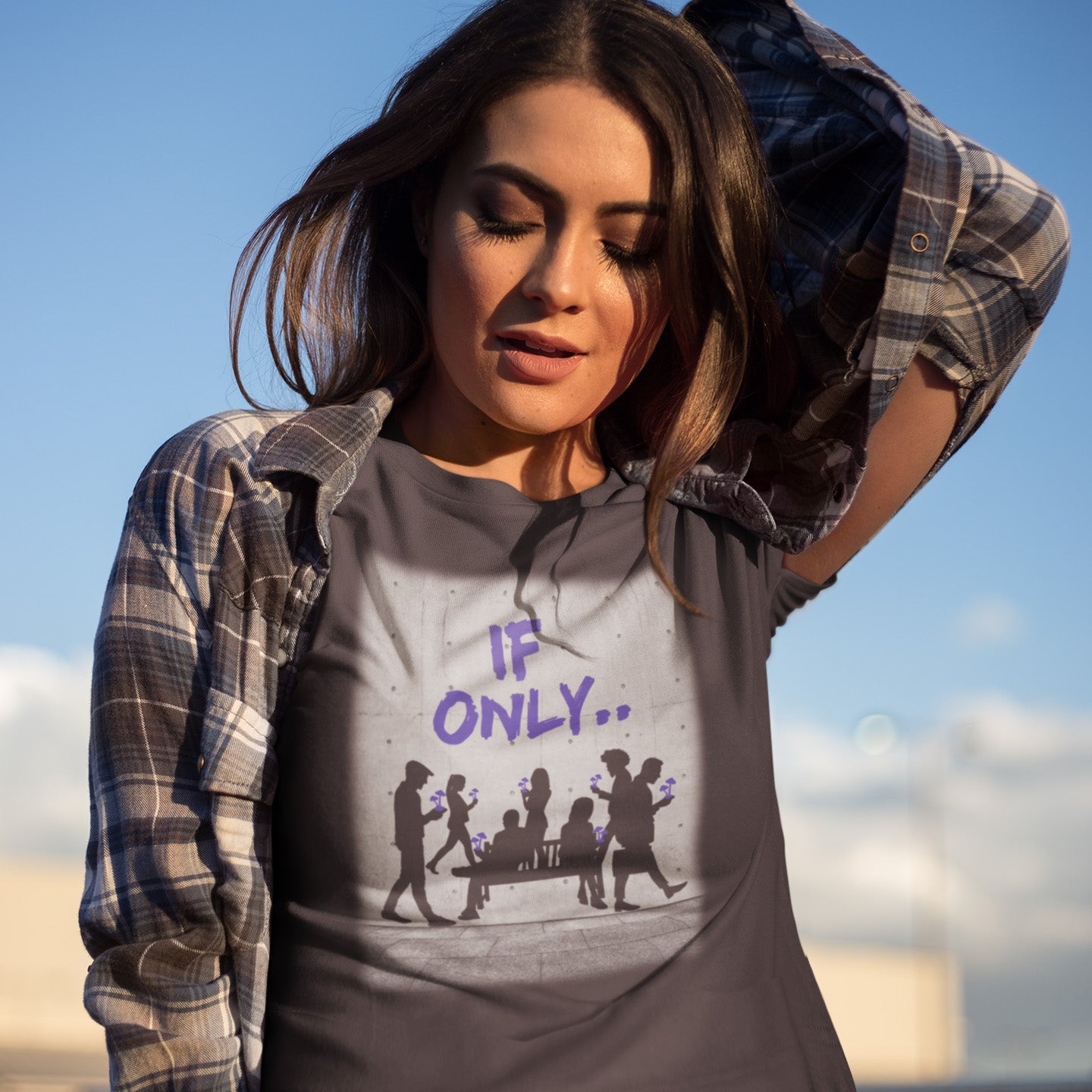 Woman wearing a t-shirt with 'IF ONLY...' design outdoors. An anti mobile phone abuse t shirt in a stencil graffiti art design. Wouldn't it be a better world if people had something more mind expanding to be obsessed with other than a mobile phone. Made from 100% organic ring-spun cotton, this anti mobile phone abuse t shirt is unisex, high-quality, super comfy, and best of all, eco-friendly.