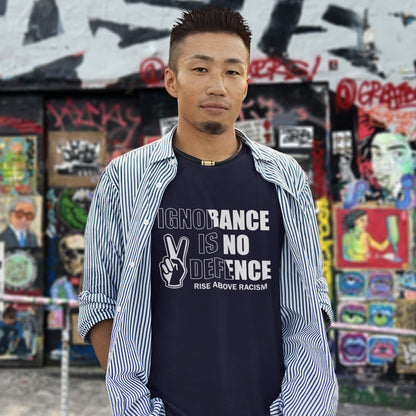 Man wearing a t-shirt with a message against racism in front of a colourful graffiti wall. An anti-racist t-shirt to remind people that ignorance is no defence against prejudice. This unique racial equality t-shirt design promotes understanding and brotherhood to achieve peace in the world. Made from 100% organic ring-spun cotton, this anti racism t-shirt is unisex, high-quality, super comfy, and best of all, eco-friendly.