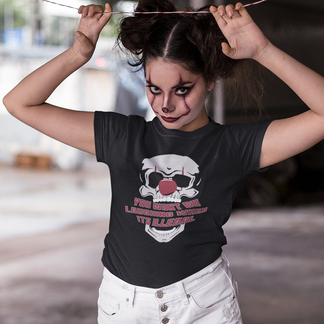 Woman wearing clown makeup, wearing a black t-shirt featuring a graphic of a skull wearing a red clown nose, with the text 'YOU WON'T BE LAUGHING WHEN IT'S ILLEGAL' in red and white outlined lettering below.