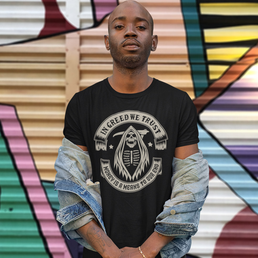 Man wearing a black t-shirt with a graphic design and text, standing in front of a colourful mural. A broken society t shirt implying we have made greed our new God. If you believe our obsession with money is lowering the standards of society, help create social awareness with this anti capitalism t shirt. Could it be that money worship will be the end of us ? Made from 100% organic ring-spun cotton, this broken society t shirt is unisex, high quality, super comfy, and best of all, eco-friendly.