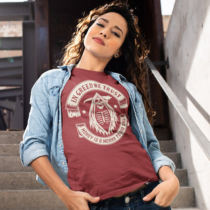 Woman wearing a maroon t-shirt with a graphic design and text, standing outdoors. A broken society t shirt implying we have made greed our new God. If you believe our obsession with money is lowering the standards of society, help create social awareness with this anti capitalism t shirt. Could it be that money worship will be the end of us ? Made from 100% organic ring-spun cotton, this broken society t shirt is unisex, high quality, super comfy, and best of all, eco-friendly.