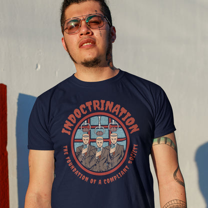 Man wearing a navy blue t-shirt with a graphic design and text. A conspiracy theory t shirt exposing indoctrination as the foundation of modern society. What we believe before we realise we are being lied to shapes our lives until we take back our own opinions. Made from 100% organic ring-spun cotton, this non conformist t shirt is unisex, high quality, super comfy, and best of all, eco-friendly.