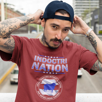 Man wearing a red t-shirt with 'Indoctrination' text and graphic, outdoors. A political t-shirt with satirical look at nationalism, an insight into a very dark future for any nation under a controlling government. Display your social awareness with this unique design. Made from 100% organic ring-spun cotton, this political t-shirt is unisex, high-quality, super comfy, and best of all, eco-friendly.