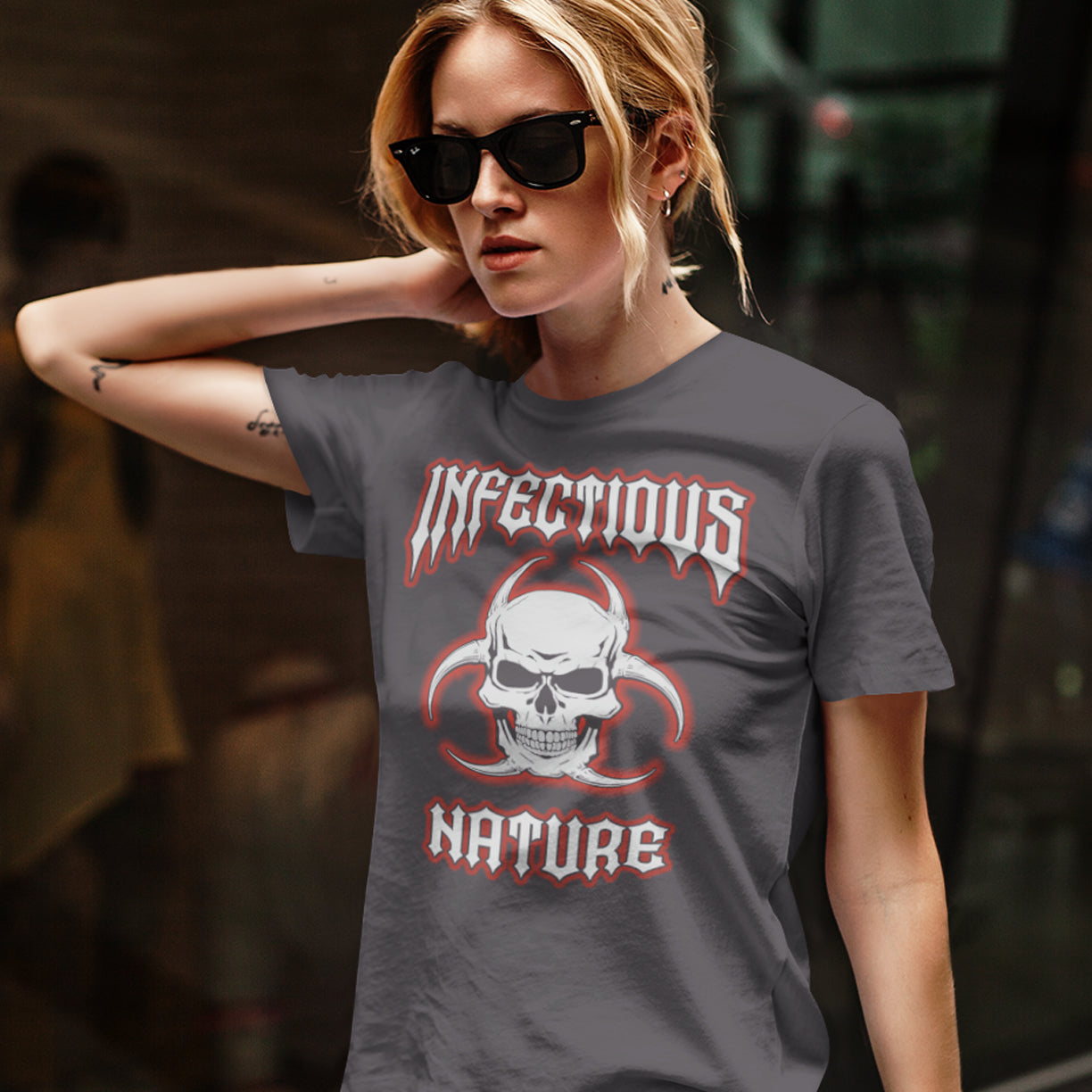 Person wearing an anthracite t-shirt with a graphic design and text. This urban art t shirt design has a double meaning. You can have an infectious nature but it's also within our nature, as a race, to infect. Made from 100% organic ring-spun cotton, this social awareness t shirt is unisex, high-quality, super comfy, and best of all, eco-friendly.