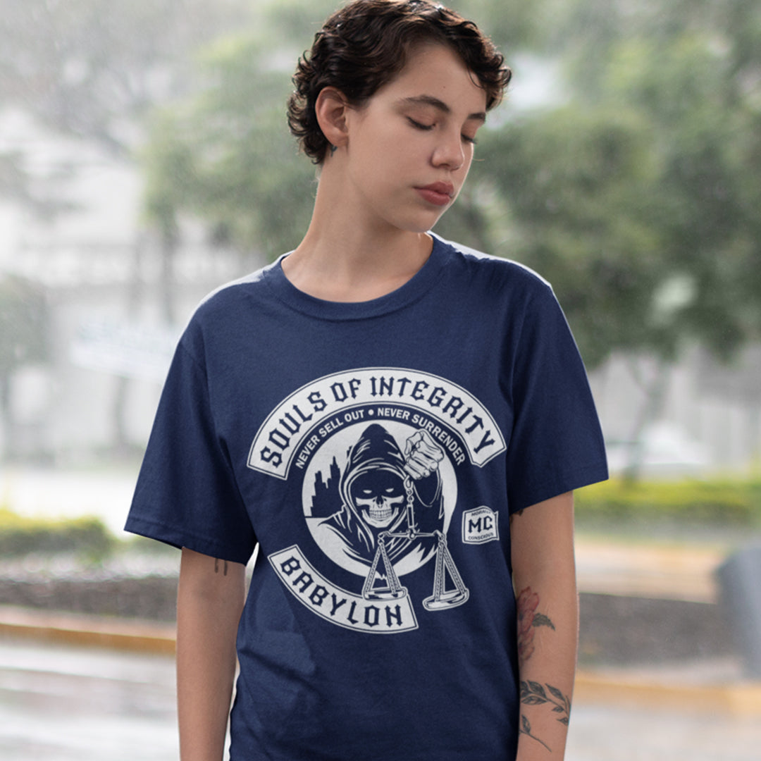 Person wearing a navy blue t-shirt with a graphic design outdoors. A social awareness t shirt promoting ethics and morality. A spoof motorcycle club design for people who still have integrity. This design satirically representing how few people are left with a moral conscience in a corrupt world, or as the Rastafarians call it, BABYLON. Made from 100% organic ring-spun cotton, these social issues t shirts are unisex, high-quality, super comfy, and best of all, eco-friendly.