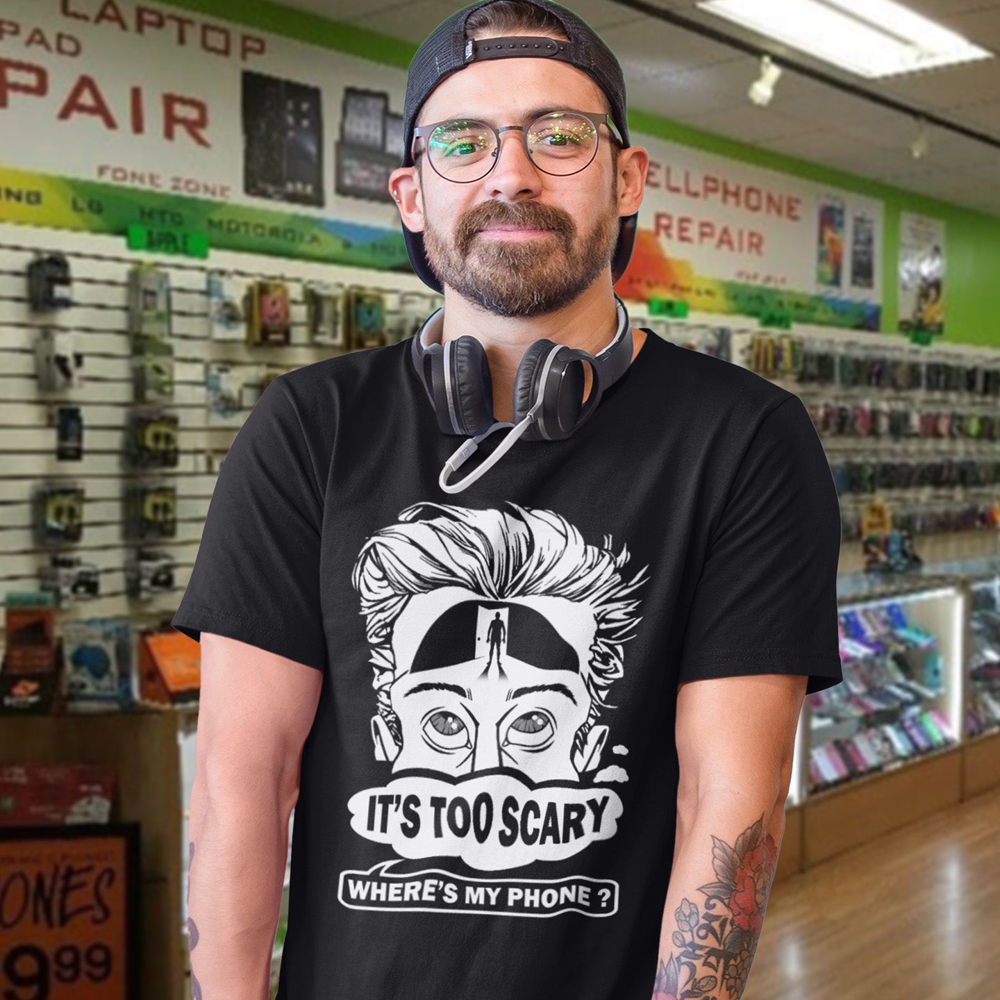Man wearing a black t-shirt with a graphic design in a store setting. An anti-mobile phone abuse t-shirt highlighting the effects on the mind of smart phone over use in the place of thinking. A view of how mobile phones have taken over thinking and left us with dark unexplored corridors in our minds. Made from 100% organic ring-spun cotton, this social awareness t-shirt is unisex, high-quality, super comfy, and best of all, eco-friendly.