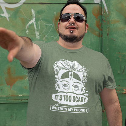 Man wearing a khaki t-shirt with a graphic design and text, standing against a green wall with graffiti. An anti-mobile phone abuse t-shirt highlighting the effects on the mind of smart phone over use in the place of thinking. A view of how mobile phones have taken over thinking and left us with dark unexplored corridors in our minds. Made from 100% organic ring-spun cotton, this social awareness t-shirt is unisex, high-quality, super comfy, and best of all, eco-friendly.