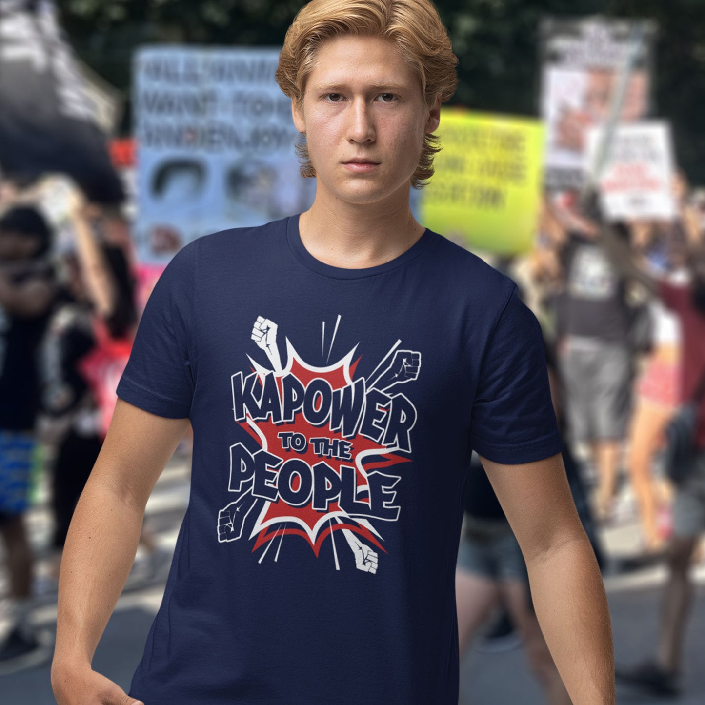 Person wearing a French navy blue t-shirt with 'Kapower to the People' text in a protest setting. This anti government t shirt packs a punch with this humorous play on the slogan 'Power to the people', with a comic book twist. Support true democracy with this funny political message. Made from 100% organic ring-spun cotton, this unisex non conformist t shirt is a total must-have. It's high-quality, super comfy, and best of all, eco-friendly.