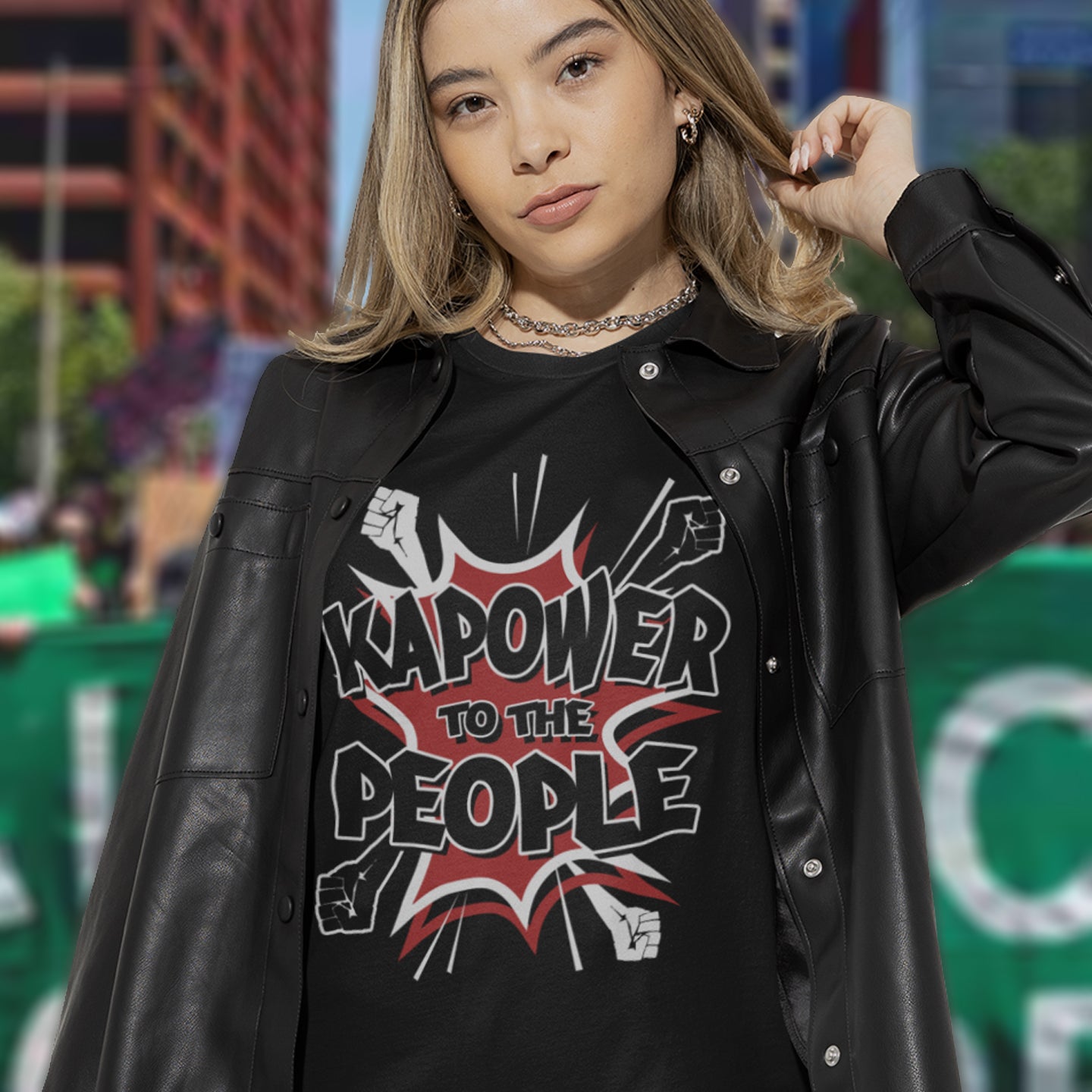 Person wearing a black shirt with 'Kapower to the People' design in an urban setting. This anti government t shirt packs a punch with this humorous play on the slogan 'Power to the people', with a comic book twist. Support true democracy with this funny political message. Made from 100% organic ring-spun cotton, this unisex non conformist t shirt is a total must-have. It's high-quality, super comfy, and best of all, eco-friendly.